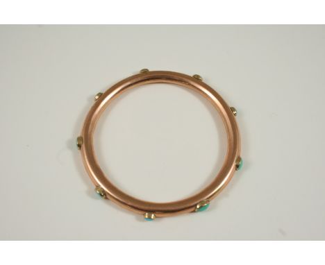 A TURQUOISE AND GOLD SLAVE BANGLE the 9ct. gold bangle is set with oval turquoise cabochons, 25.5 grams.