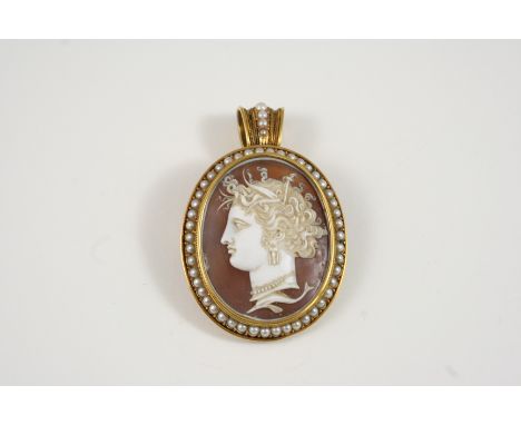 A LATE VICTORIAN OVAL CARVED SHELL CAMEO BROOCH PENDANT depicting the profile of a classical woman, set within a gold surroun