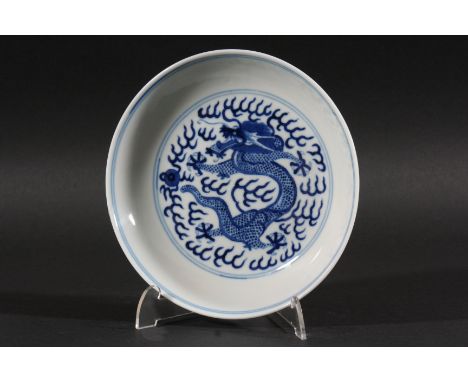 CHINESE SAUCER DISH,  Qing Dynasty, blue painted with a central dragon chasing the flaming pearl inside a line border, the un