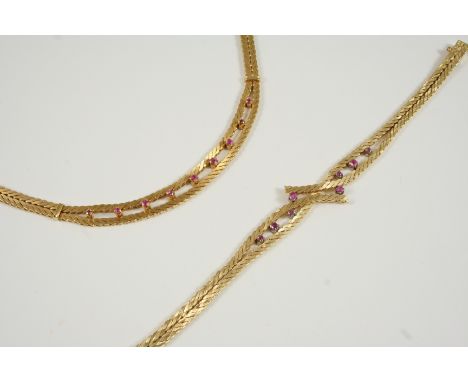 AN 18CT. GOLD AND RUBY NECKLACE the herringbone link necklace is centred with nine graduated circular-cut rubies, with concea