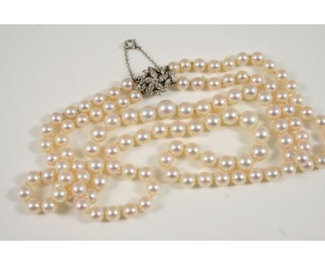 A SLIGHTLY GRADUATED TWO ROW CULTURED PEARL NECKLACE the pearls graduate from approximately 6.8mm. to 9.5mm. to a flowerhead 