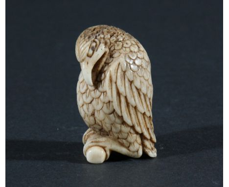 THREE JAPANESE NETSUKE, the first carved as a humorous bird of prey, height 4.5cm, together with a monkey eating a nut, 4cm a