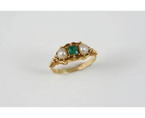 AN EMERALD AND PEARL RING the square-shaped emerald is set with two half pearls, in gold ornate setting and shank. Size O.