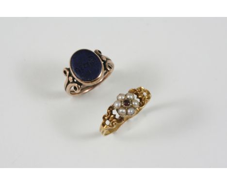 A GEORGIAN GOLD AND GEM SET RING centred with a circular-cut garnet within a surround of half pearls, with gold foliate openw