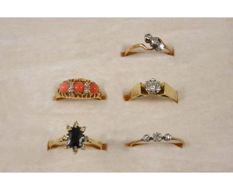 A CORAL AND DIAMOND RING the three coral cabochons are set with four rose-cut diamonds, in 18ct. gold, size O, a diamond soli