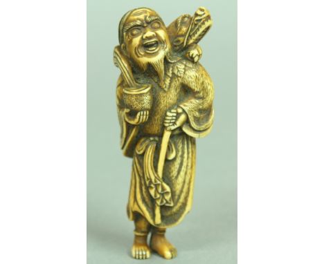 JAPANESE IVORY NETSUKE OF A MAN AND DRAGON, the man standing holding a staff and bowl with the dragon wrapped around his shou