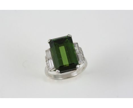 A TOURMALINE AND DIAMOND RING the rectangular-shaped green tourmaline is set with two baguette-cut diamonds  and millegrain s