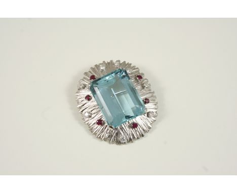 AN AQUAMARINE AND GOLD BROOCH the large step-cut aquamarine is set within a white gold textured surround, mounted with circul