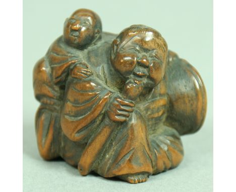 JAPANESE WOODEN NETSUKE OF TWO OTTERS, signed, 2.8cm; together with another of man carrying a child, signed (2)