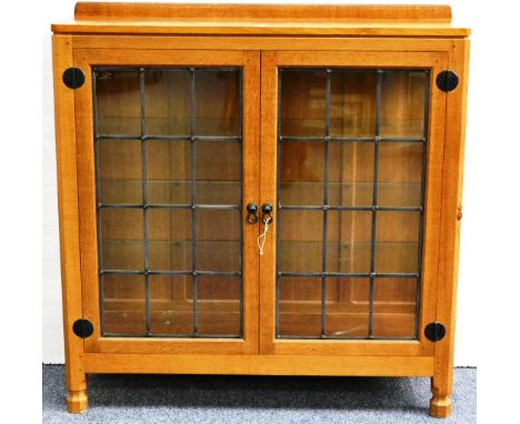 A Robert ''Mouseman'' Thompson Oak Display Cupboard, with raised upstand, above two leaded glazed doors enclosing three glass