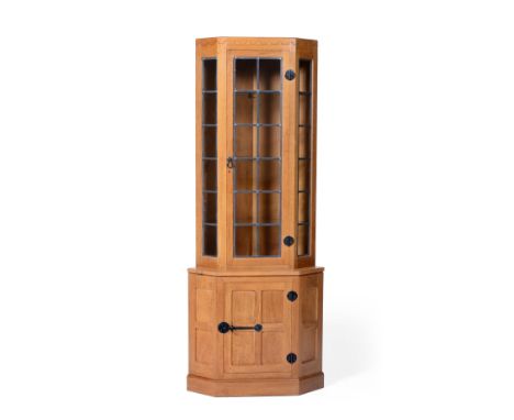 A Robert ''Mouseman'' Thompson Oak Corner Display Cupboard, penny moulded frieze, the upper section with leaded glazed door a