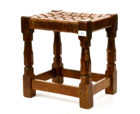 A Robert ''Mouseman'' Thompson Oak Stool, with lattice leather top, on four octagonal legs joined by stretchers, with carved 