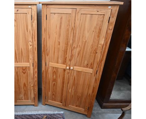 A modern pine wardrobe with a pair of full-length panelled doors enclosing a hanging rail beneath a single shelf, 186 cm high