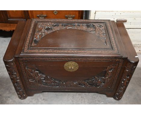 A large Chinese hardwood and camphor lined trunk carved with figures, dragons and idyllic landscape scenes, 102 cm wide x 54 