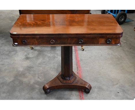 A Regency mahogany card table, the folding top with crimson baize lining and floral roundels applied to the frieze, raised on