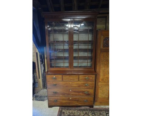 A 19th century mahogany and satin strung bookcase on chest with a pair of glazed doors enclosing four adjustable shelves on a