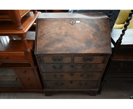 A George III mahogany fall-front bureau with fitted interior over two short and three long graduated drawers, raised on brack