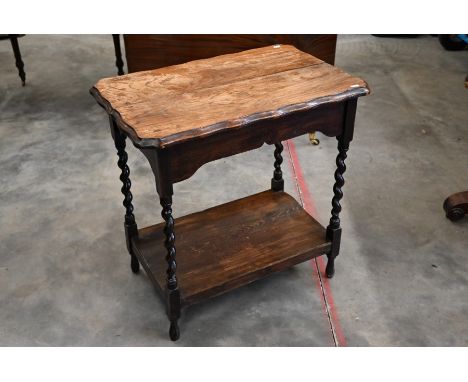 An early 20th century oak two-tier lamp table with scalloped rectangular top on barley-twist supports, 70 cm wide x 45 cm dee