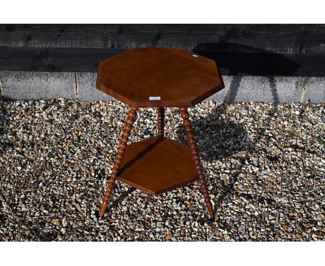 A late Victorian birch occasional table with bevelled octagonal top raised on three bobbin turned legs united by an open unde
