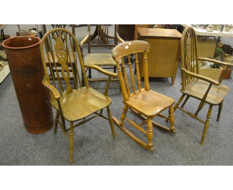 A north country spindle back beech rocker; a pair of Ercol style wheel back carvers; a walrus fibre cylindrical stick stand (