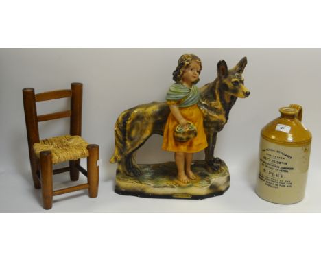 A chalk model of an Alsation and Girl, c.1930's;  a stoneware flagon; a small rush seated ladder back chair (3)