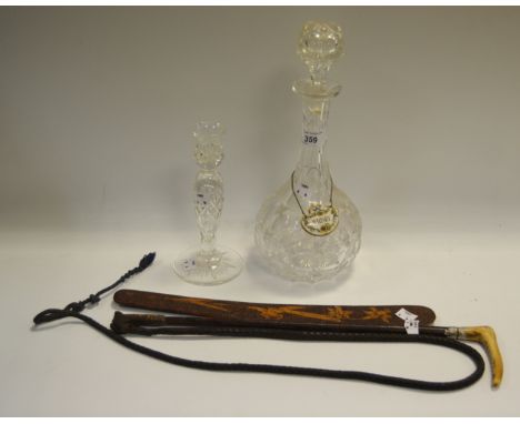 A cut glass globe and shaft decanter with ceramic whisky label; a glass candlestick; a horn handled riding crop; a poker work