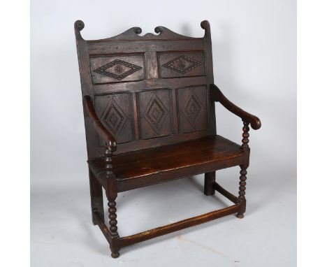 An 18th century oak settle of small size, with lozenge carved 5-panel back and bobbin turned supports, length 93cm, height to