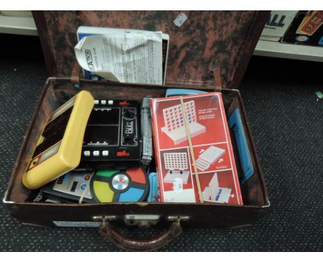 A vintage suitcase containing various electronic games including Blip, Logic 5, AmazeATron etc