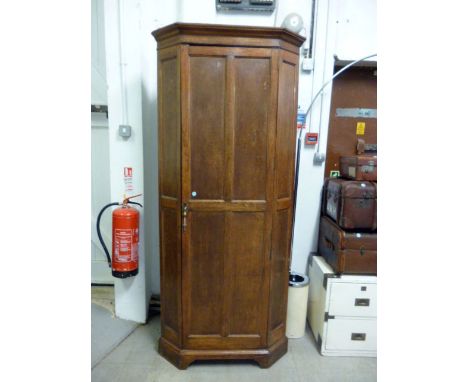 An oak corner wardrobe,  with upper interior shelf and clothes hanger below, approx 213cm H