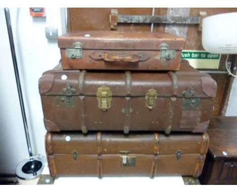 A vintage leather suitcase,  together with two vintage trunks, all different sizes