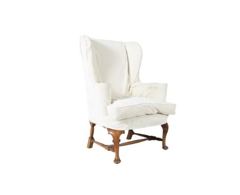 A GEORGE III WALNUT FRAMED UPHOLSTERED WING BACK ARMCHAIR, covered in a tapestry style material and raised on carved cabriole