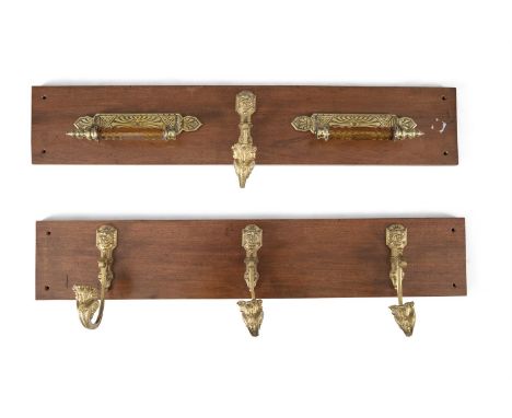 TWO BRASS AND AMBER GLASS TIE RACKS AND A HOOK, mounted on a timber panel. The panel 92 x 12cm