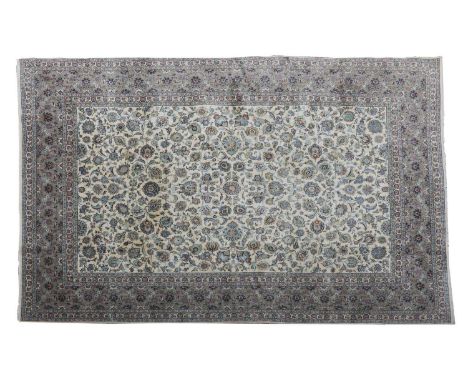 A Kashan carpet,20th century, the field with scrolling foliate motifs, within further floral and foliate borders, on a light 