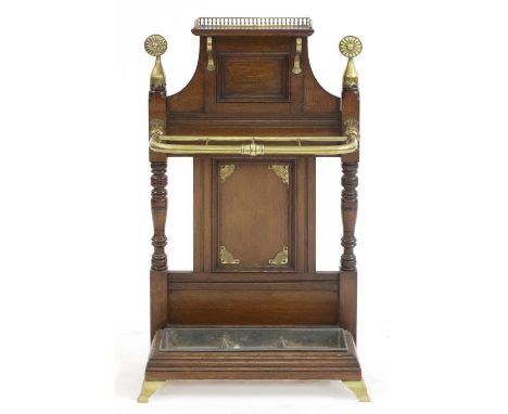 An Aesthetic oak and brass stick stand, attributed to James Shoolbred,c.1880, having a brass galleried shelf over a brass sti