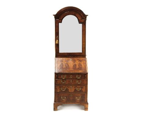 A George I walnut dome top bureau cabinet, c.1710, with arched cornice, candle slide and mirrored door to the top half, enclo