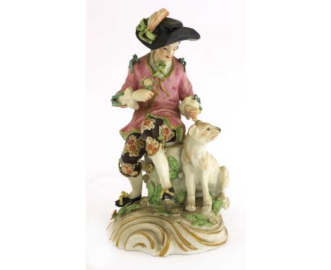 A Samson figure of a young man and his dog,c.1765, in the Chelsea style, he seated on a floral-sprigged rock, wearing a large