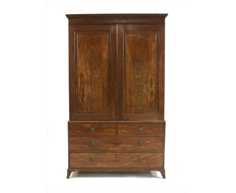 A George III mahogany linen press,by Gillows of Lancaster, the two panelled doors enclosing five slides over two short and tw