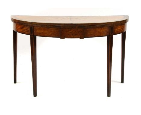 A George III inlaid satinwood demilune card table,the fold-over top inlaid with radiating husks and stiff leaves on square ta