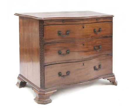 A George III mahogany serpentine commode, c.1780, with a brushing slide, three long drawers, cast brass handles, blind fret a