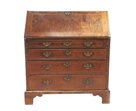 A George III walnut and feather banded bureau,opening to reveal a fitted interior, the fall front over four graduated long dr