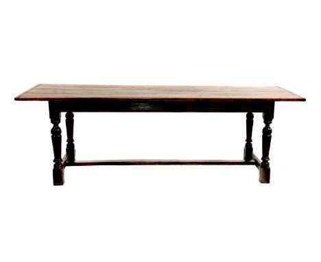 An oak refectory table,17th century and later, the four-plank top with cleated ends, on turned baluster supports united by an