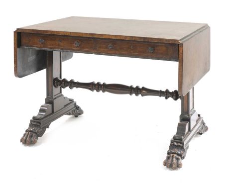 A Regency carved rosewood sofa table,with two frieze drawers and opposing dummy drawers, on end supports and paw feet joined 