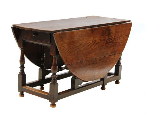An oak drop-leaf gateleg dining table,18th century, the oval top over a drawer to one end, on baluster turned supports, unite