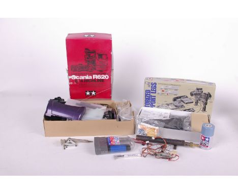 A Scania R470 Hiline tractor truck unassembled in box together with a DX5E aircraft remote and a box of Tamiya truck parts.
