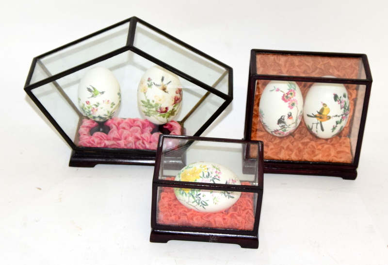 Three chinese hand painted egg display cases, each in a glazed box with