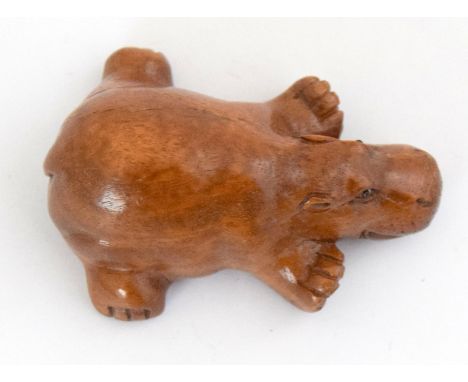 an oriental carved wooden netsuke in the form of a hippo signed