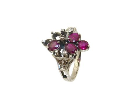 A ruby and diamond dress ring, designed as a cluster of oval shape rubies, with single cut diamond spacers and trefoil should