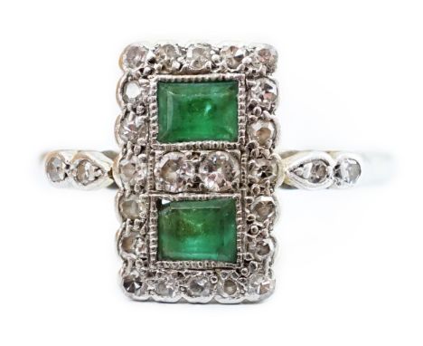 An Art Deco white metal, emerald and diamond set double cluster tablet ring, with diamondset shoulders, size K, gross weight 