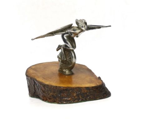 A vintage chrome plated car mascot of a winged female riding a wheel, mounted on a tree trunk cross-section, 19cm high There 