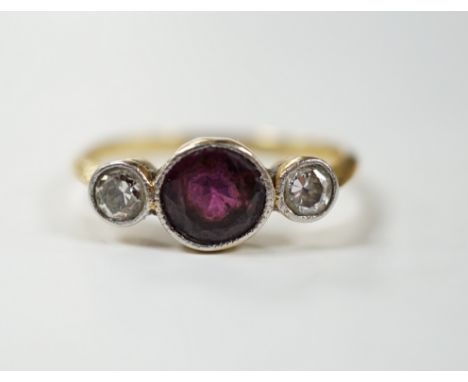 An early 20th century yellow metal and millegrain set single stone garnet and two stone diamond ring, size M, gross weight 2.